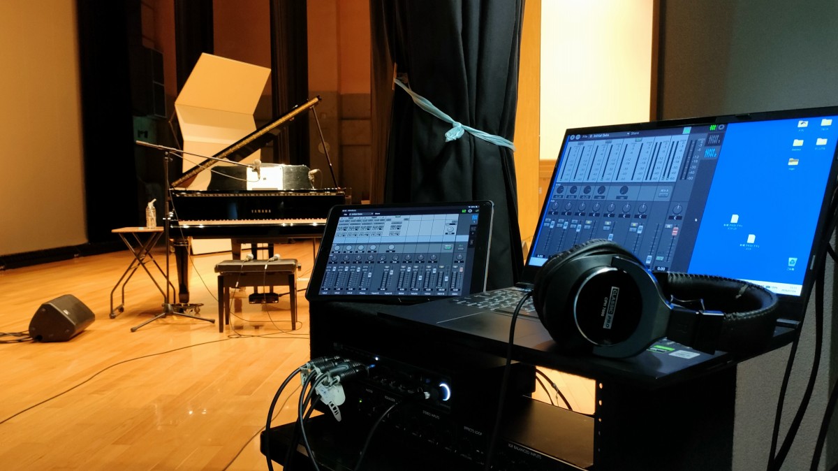 文化講演会の舞台袖に設営されたPA音響卓とグランドピアノが並ぶホールステージ。令和8年度能登川地区文化協会文化公演会の午後のやすらぎい音楽会。出演者「しゅんまり歌うます。」「Mr.Operaおじさん」。