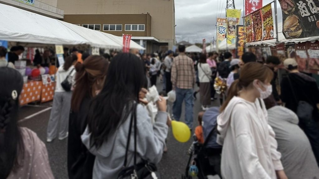 天幕テントや屋台が並び、多くの来場者で賑わう屋外マルシェエリアの様子。滋賀県東近江市のコミュニティセンターで開催された能登川ふれあいフェスタにて。